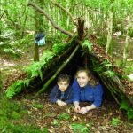 Life Changing Activities - Photograph of a boy and girl sheltering in a Bivouac